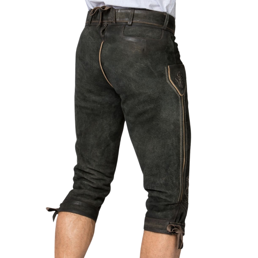 Rear angled view of deep forest green bundhosen showcasing side flap pocket with embroidery, light tan seam piping, and knee cuff laces.