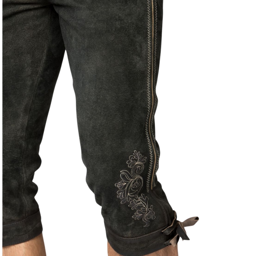 Detailed view of the lower leg on deep forest lederhosen, featuring intricate white floral embroidery and stitched side seam above tied knee cuffs.