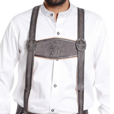 Close-up view of men's gray lederhosen suspenders with an embossed floral motif on the chest strap, worn over a white traditional shirt.